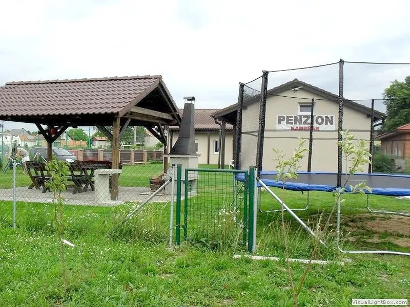 Pergola a budova penzionu ze zahrady